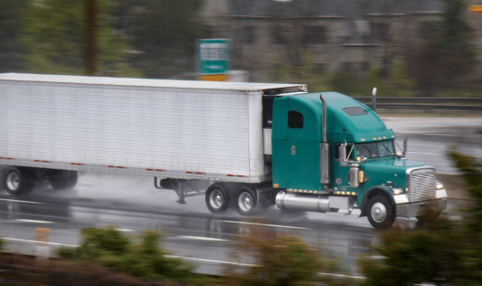 Freight truck travelling on rough and wet road